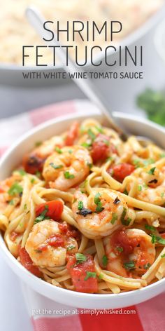 shrimp fettuccini with white wine tomato sauce in a bowl on a red and white checkered tablecloth