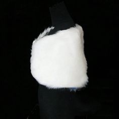 a black mannequin wearing a white fur vest