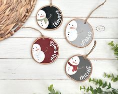 three wooden ornaments with snowmen on them