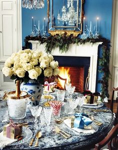 a dining room table set for christmas with white roses and candy canes on it