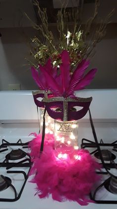 a masquerade with pink feathers and lights on the stove