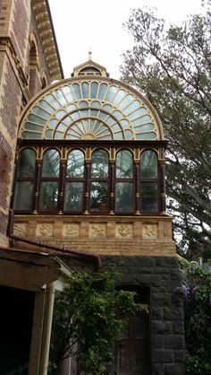 an old brick building with a large glass window on the top floor and side of it