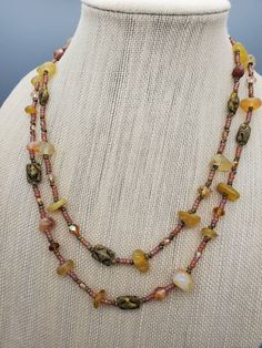 a necklace with multi colored beads on a mannequin