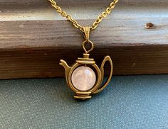 This is a fabulously bohemian Alice in Wonderland inspired necklace with a pink rose quartz gemstone pearl and a kitsch teapot pendant. Handcrafted in Finland by Selma Dreams. The necklace is made of antiqued bronze, all the materials are lead and nickel safe. There are three length options for the chain, please choose your favourite from the drop down menu. Custom length is also an option, simply leave a note with your order. Rose quartz is light pink colour crystal and is said to be the crystal of love, peace and inner balance. The necklace will be sent in a lovely little gift box ready for gifting. There are matching earrings available from my shop. If you have any questions or would like the necklace in different colour, do contact me. Spiritual Pink Charm Necklace As Gift, Pink Spiritual Charm Necklace For Gift, Spiritual Pink Charm Necklace For Gift, Whimsical Round Pendant Necklace, Handmade Pink Charm Necklaces For Mother's Day, Whimsical Adjustable Round Pendant Necklace, Handmade Pink Charm Necklace For Mother's Day, Mother's Day Pink Handmade Charm Necklace, Pink Bohemian Charm Necklace Gift