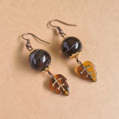 "Details * Handmade item * Dispatches from a small business in Singapore * Metal: Copper Alloy * Gemstone: Banded Agate * Location: Earrings * Earring Type : Hook * Style: Rustic Description A fan of Autumn? Reflect the season's colours with this pair of banded agate beads earrings topped with gold coloured stainless steel flower bead caps with cognac leaf czech glass beads dangles. The copper earring hooks are light weight and compliments the mix of browns and patterns of the agate beads.  As g Brown Czech Glass Teardrop Earrings, Brown Czech Glass Jewelry Gift, Brown Adjustable Earrings With Natural Stones, Handmade Brown Glass Jewelry, Handmade Amber Agate Earrings, Nickel-free Brown Czech Glass Earrings, Nickel-free Brown Earrings With Czech Glass, Nickel-free Brown Czech Glass Jewelry, Nickel Free Brown Earrings With Czech Glass