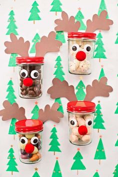 three jars with reindeer noses and candy in them on a christmas wallpapered background