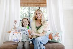 a woman and child sitting on a couch with stuffed animals