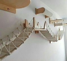 there is a staircase made out of wood and rope hanging from the wall above it