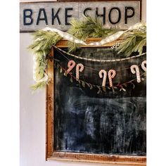 a chalkboard with christmas garland hanging from it