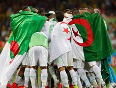 a group of soccer players huddle together