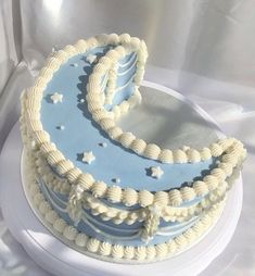 a blue and white cake sitting on top of a white platter with stars around it