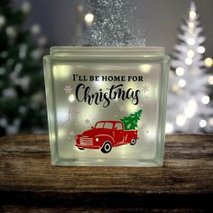 a glass block that says i'll be home for christmas with a red truck