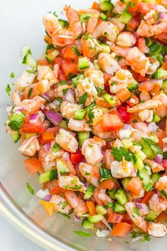 a bowl filled with shrimp and veggies on top of a table