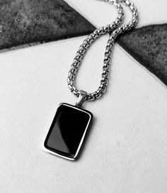 《《  FOR YOUR JOURNEY COLLECTION  》》 THE DETAILS The "BLACK ONYX TAG" Necklace is designed with an exquisitely detailed Silver Stainless Steel Mini Dog Tag Pendant, with a rich Black Onyx Gemstone Inlay, hung from a Silver Stainless Steel Box Chain available in your choice of length! GEMSTONE BENEFITS BLACK ONYX: Known as the "PROTECTION" Stone, often worn for its abilities to harness one's inner strength while increasing self control and self discipline, to encourage an increased focus and attention to protect against negative energies & thoughts. 🔷️🔶️🔷️View the entire FOR YOUR JOURNEY COLLECTION here: https://www.etsy.com/shop/mrmackjewelry/?section_id=27030044 MATERIALS * 3/4" × 1/2" Silver Stainless Steel Black Onyx Gemstone Inlay Mini Dog Tag Pendant  * 3mm Silver Stainless Steel Bo Formal Black Stainless Steel Necklace, Black Necklace With Adjustable Chain And Rectangular Pendant, Modern Black Jewelry With Silver Chain, Modern Black Necklace With Box Chain, Classic Black Chain Jewelry, Classic Black Jewelry With Chain Detail, Formal Black Rectangular Necklace, Black Stainless Steel Dog Tag Jewelry, Black Stainless Steel Dog Tag Necklace