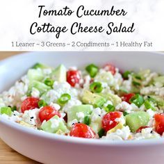 a white bowl filled with cucumber and cottage cheese salad on top of a wooden table