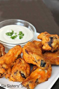 some fried food on a white plate with ranch dip