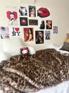 a bedroom with pictures on the wall and a teddy bear sitting on top of it