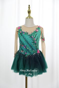 a green and pink dress on a mannequin