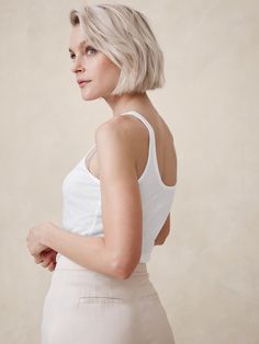 Ideal for channeling the season's ode to 90s sheer styles, this fitted tank is cut from a semi-sheer, ribbed fabric so you can layer it or wear it solo as you please.  Fitted.  Sustainability: Made with TENCEL™ lyocell, a sustainably sourced fiber from responsibly-harvested trees.  Scoop neck.  Straight hem.  Fitted.  Sleeveless.  Hip length.  Model: Size S, 5'10" (178cm). Summer Ribbed Stretch Tank Top, Ribbed Stretch Tank Top For Summer, Summer Stretch Ribbed Tank Top, Chic Ribbed Everyday Tank Top, Trendy Ribbed Camisole For Spring, Everyday Fitted Ribbed Tank Top, Chic Everyday Ribbed Tank Top, Summer Ribbed Stretch Camisole, Fitted Knit Tank Top For Everyday