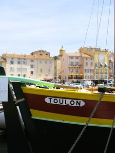 there is a boat that is docked in the water next to other boats and buildings