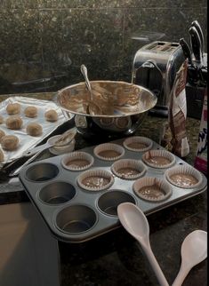 a pan filled with cupcake batter next to a muffin tin on top of a counter