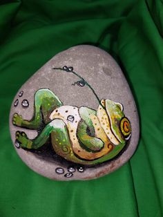 a painted rock with a lizard laying on it