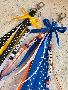 four different colored lanyards tied to each other on a table with polka dots