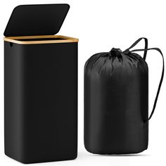 a black trash can next to a black bag on a white background with a wooden lid