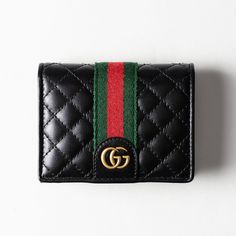 This Gucci GG Marmont Card Case Wallet is crafted from black quilted leather with gold-tone hardware, and Web accent. Leather & nylon lining with card slots, open pocket and currency zipper pocket at interior with snap closure. Includes dust bag and box. Measuring: 4.5 in. L, 3.5 in. H, 1 in. D. Very good condition: