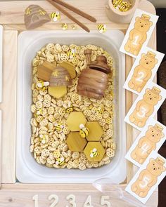 a wooden tray filled with lots of different types of food next to cut out numbers