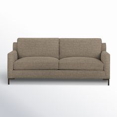 a beige couch sitting on top of a white floor