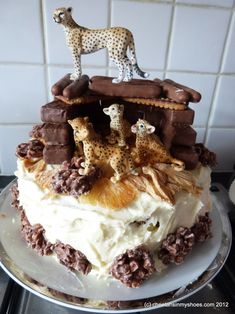 a cake decorated with giraffes and other animal figurines on top of it