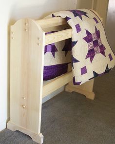 a wooden bunk bed with purple and white quilt