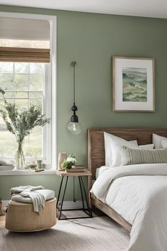 a bedroom with green walls, white bedding and wooden furniture in front of a window