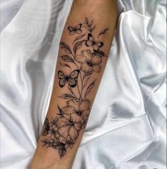 a woman's arm with flowers and butterflies on it