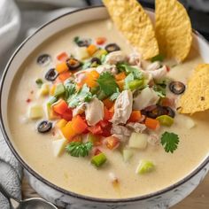 a white bowl filled with soup topped with tortilla chips