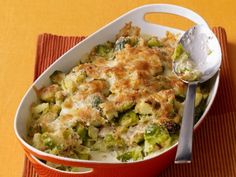 a casserole dish with broccoli and cheese in it on a place mat