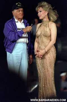 a man and woman standing next to each other in front of a microphone on stage