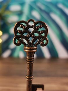 an antique key is sitting on a wooden table