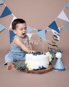 a young boy sitting in front of a cake