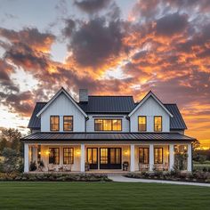 a large white house sitting on top of a lush green field under a cloudy sky