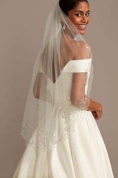 a woman in a wedding dress with a veil on her head