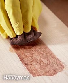 a person wearing yellow gloves and cleaning the floor with a cloth on top of it