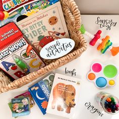 a basket filled with books and toys sitting on top of a white table next to other items