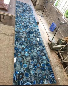 a blue and white mosaic tile floor in an indoor area with wood pallets on the ground