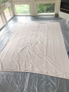 a large sheet of plastic sitting on top of a floor in front of a window