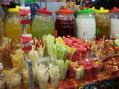 there are many different types of food on display at this market stall, including pickles and juices