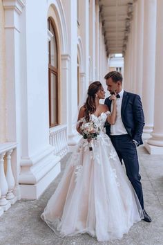 the bride and groom are standing together outside