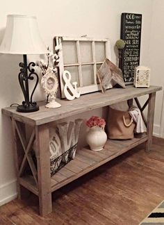 a wooden table topped with vases and other items next to a wall mounted sign