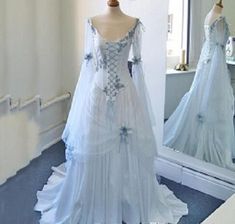 a white wedding dress on display in front of a mirror